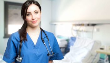 Nurse standing in front of hospital bed