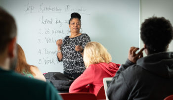 Trocaire professor teaching students in a traditional classroom setting.